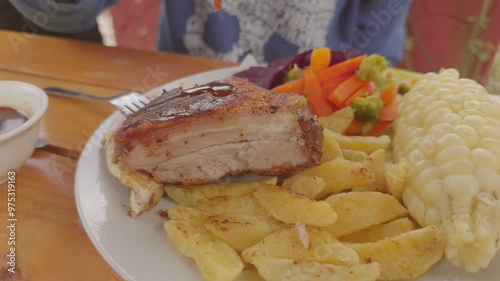 Video 4k de delicioso chancho al cilindro con papas fritas, ensalada y salsa a la BBQ