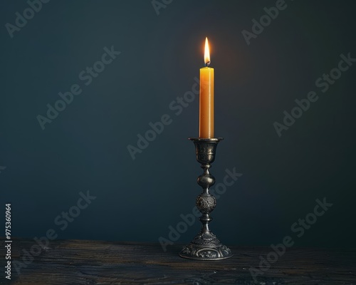 A minimalist shot of a single silver candle holder with a flickering candle in a dark room