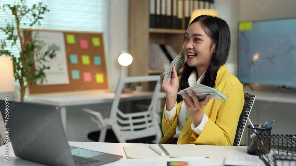 Asian businesswoman, young woman in office holding stack of money, counting banknotes, keeping track of financial details, expenses, financial business accounts in modern office calculation concept.