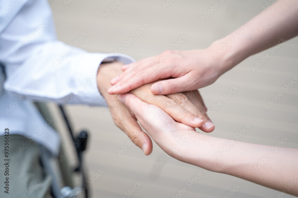 シニア男性の手を握る介護施設スタッフの手