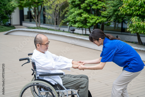 車いすから立ち上がる介助をする介護施設スタッフ