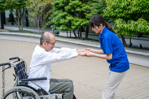 車いすから立ち上がる介助をする介護施設スタッフ