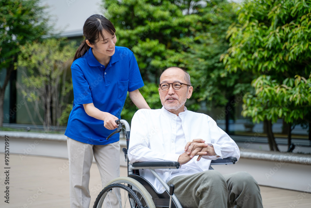 車いすのシニア男性と介護施設スタッフ 車いすのシニア男性と介護施設スタッフ