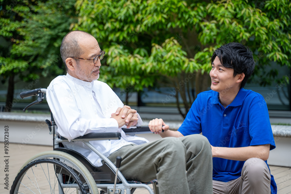 車いすのシニア男性と介護施設スタッフ 車いすのシニア男性と介護施設スタッフ