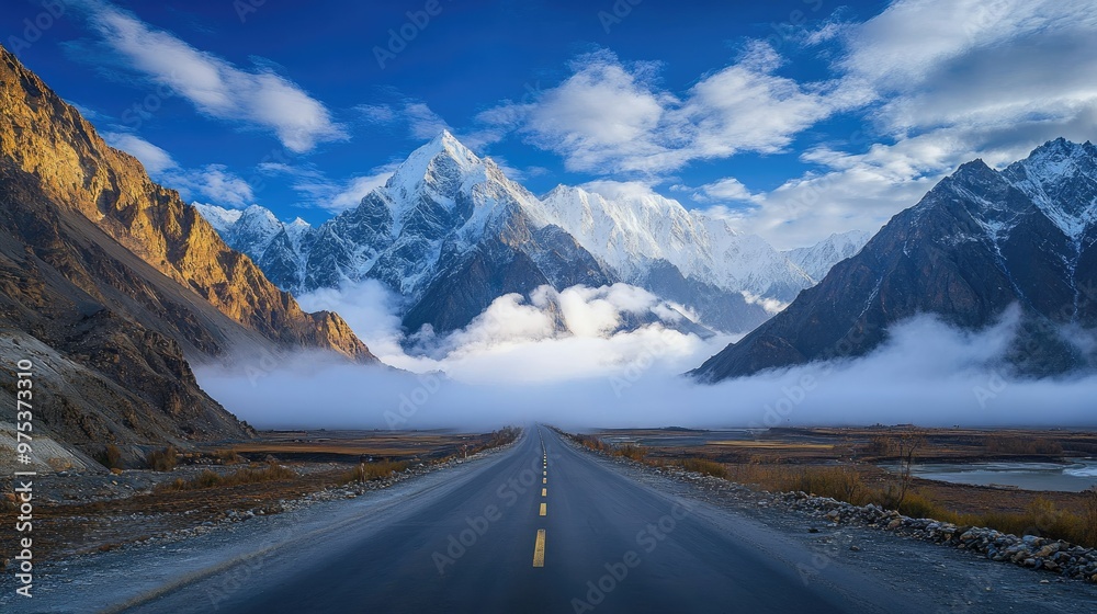 A stunning view of cloud-covered Passu Cones with the Karakoram Highway stretching through the calm, picturesque landscape of Gojal, Hunza Valley.