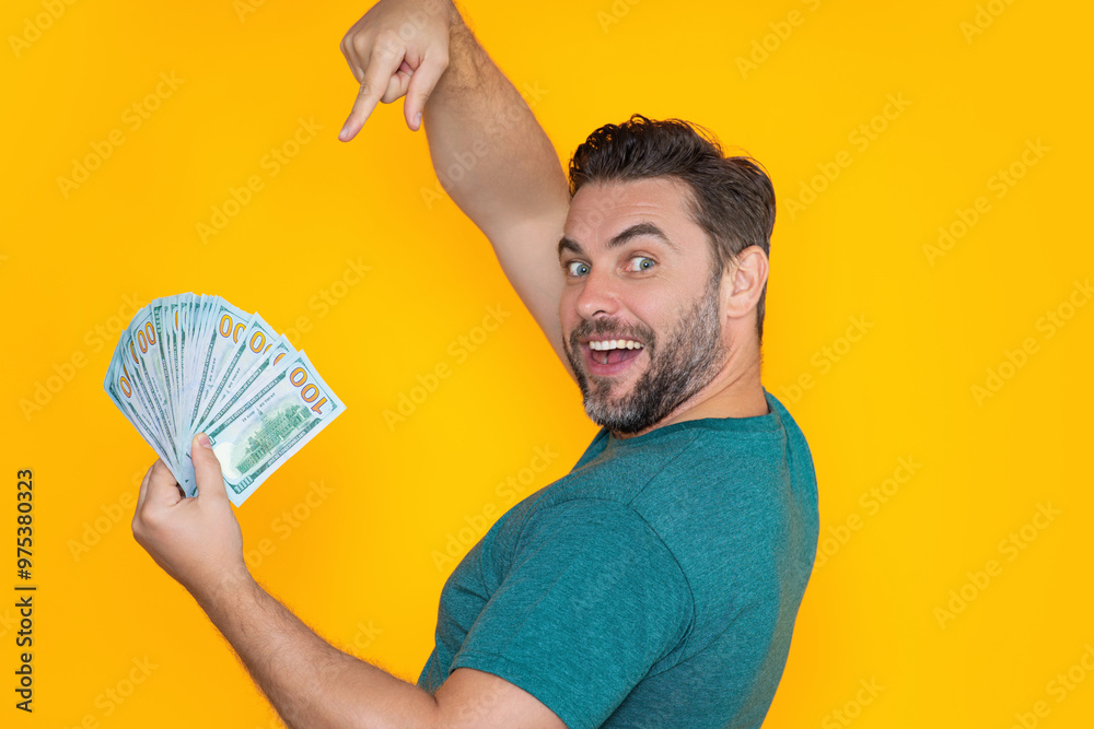 Good payment. Handsome man holding money isolated over grey studio. Money in dollar banknotes. Pile of cash, finance, investment and money saving. Good payment. Handsome man holding money isolated over grey studio. Money in dollar banknotes. Pile of cash, finance, investment and money saving.