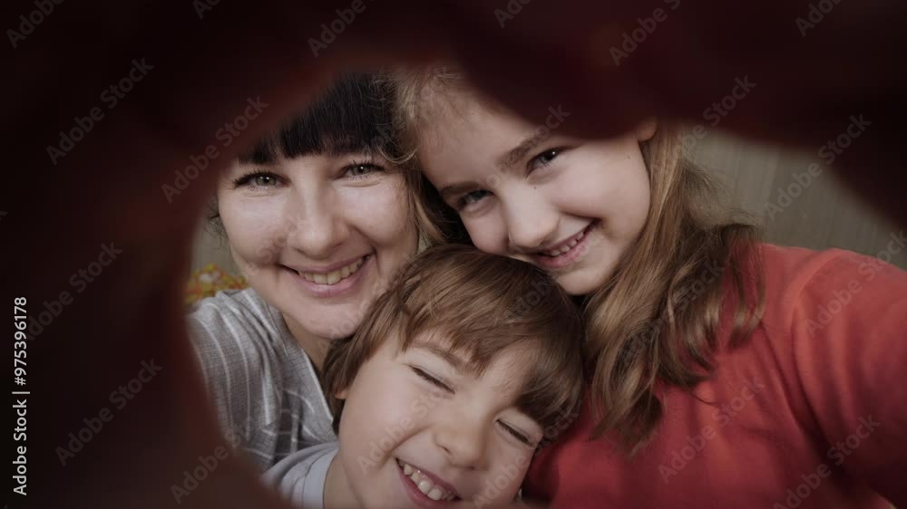 Mother and kids making heart shape from hand at home. Portrait happy children with mother join hands forming heart shape of giving love, children mum connection, cute kids mom looking at camera.