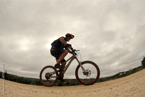 Cyclist rides through the sand on a cloudy day