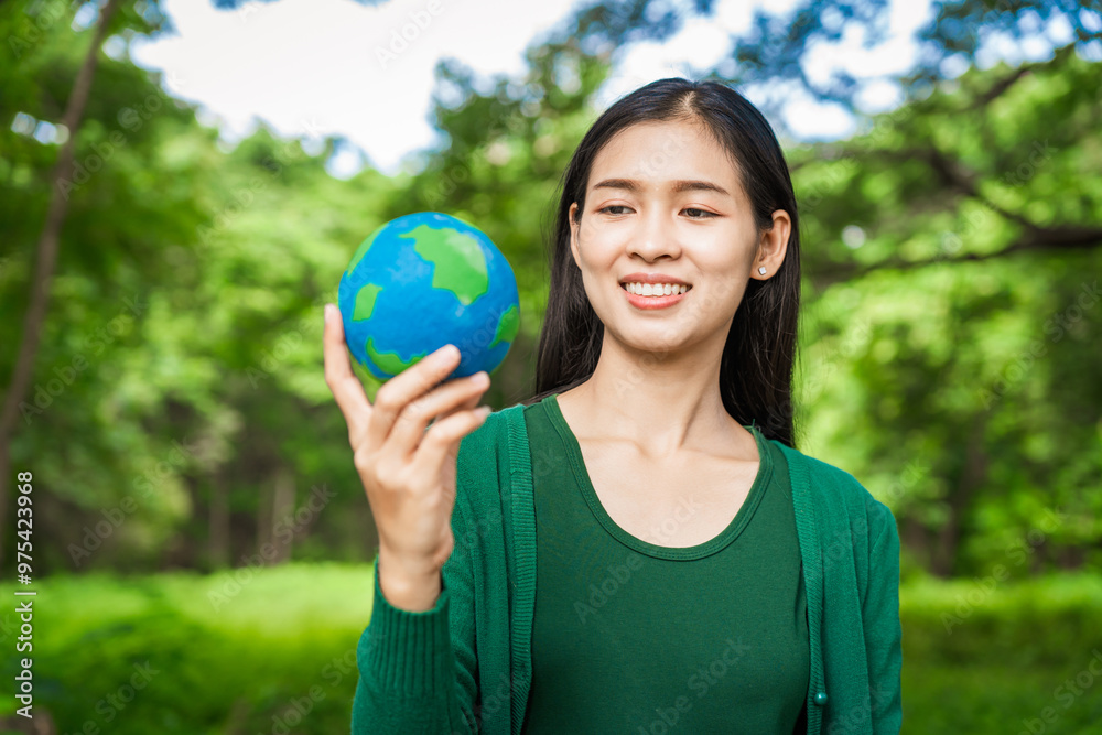 Forest conservationist holds small globe in hands, symbolizing global responsibility for protecting planet. Standing outdoors in green park, sustainability, commitment to achieving net-zero impact. Forest conservationist holds small globe in hands, symbolizing global responsibility for protecting planet. Standing outdoors in green park, sustainability, commitment to achieving net-zero impact.