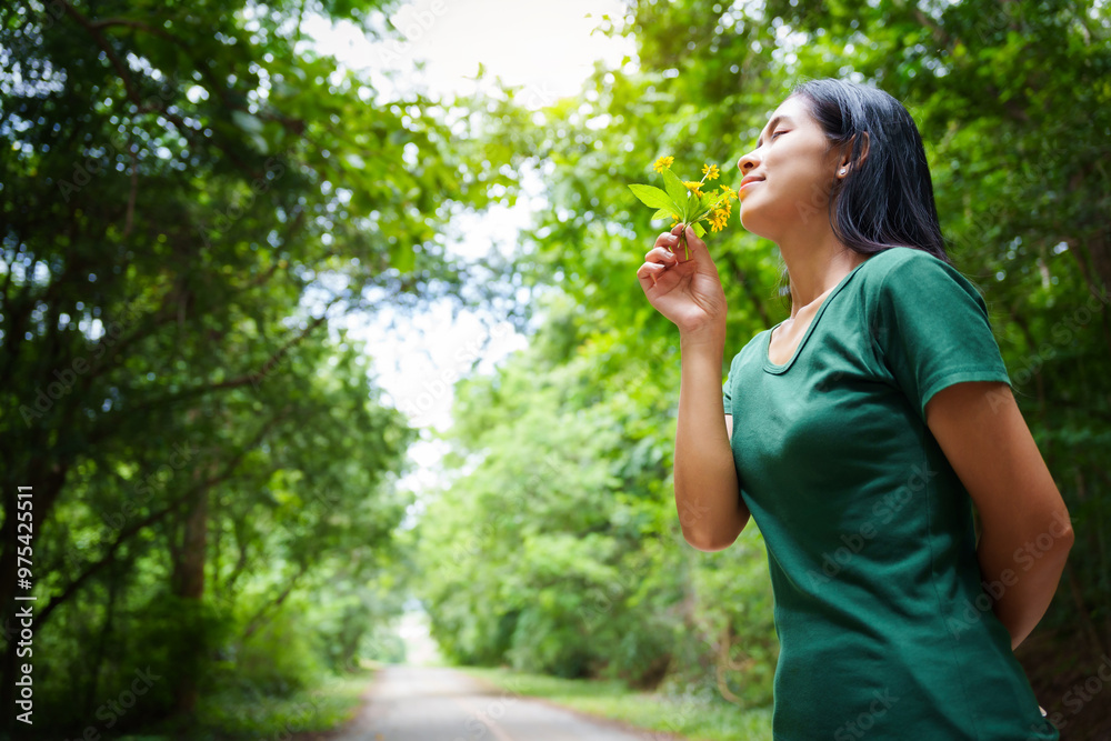 A cheerful young asian woman enjoys a sunny day outdoors, holding a vibrant bunch of yellow flowers. Smiling in a green field, she embodies the joy and freedom of summer in the countryside. A cheerful young asian woman enjoys a sunny day outdoors, holding a vibrant bunch of yellow flowers. Smiling in a green field, she embodies the joy and freedom of summer in the countryside.
