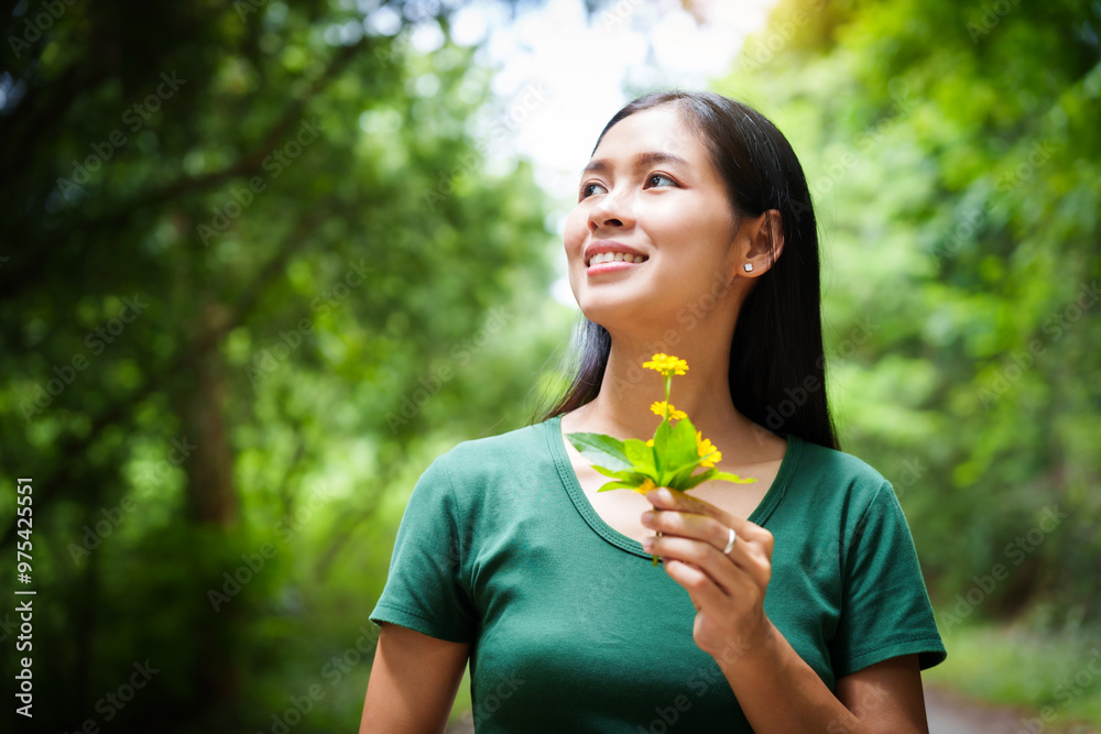 A cheerful young asian woman enjoys a sunny day outdoors, holding a vibrant bunch of yellow flowers. Smiling in a green field, she embodies the joy and freedom of summer in the countryside. A cheerful young asian woman enjoys a sunny day outdoors, holding a vibrant bunch of yellow flowers. Smiling in a green field, she embodies the joy and freedom of summer in the countryside.