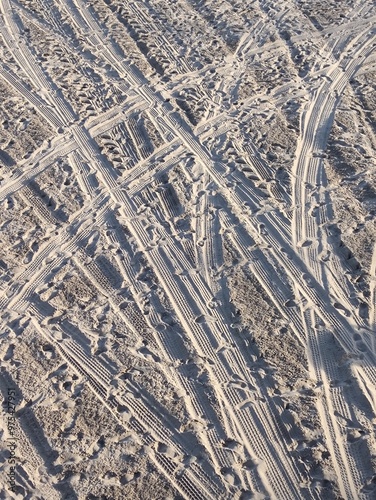 An aerial view of a sandy terrain with crisscrossing tracks and trails photo