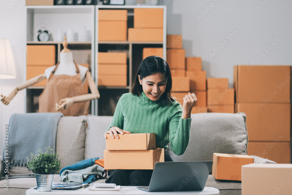 Asian SME business women use laptop computer checking customer order online shipping boxes at home. Starting Small business entrepreneur SME freelance. Online business, Work at home concept. Asian SME business women use laptop computer checking customer order online shipping boxes at home. Starting Small business entrepreneur SME freelance. Online business, Work at home concept.