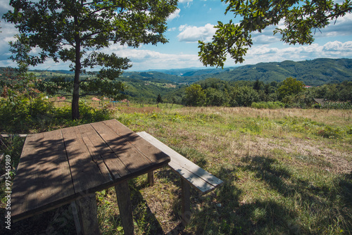 Bench on the hill with view on valley in background photo