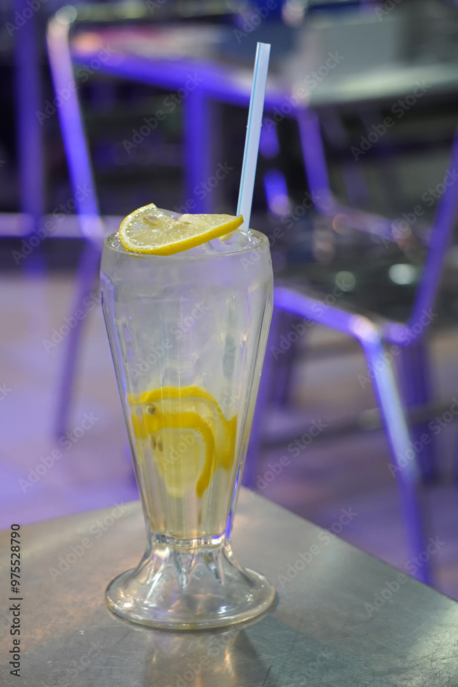 a tall glass filled with a refreshing lemon drink, garnished with a lemon wedge and a straw a tall glass filled with a refreshing lemon drink, garnished with a lemon wedge and a straw