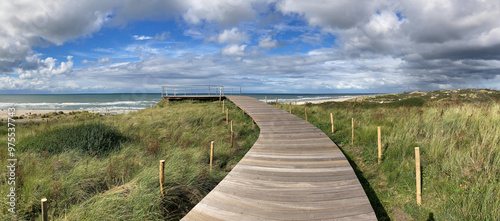 Fototapeta Naklejka Na Ścianę i Meble -  panorama view of wooden boardwalk over dunes to lookout on top of Atlantic wall