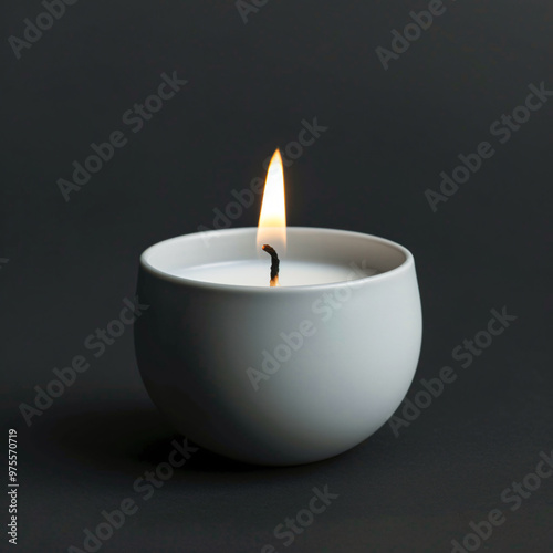 Front view of little burning candle on black