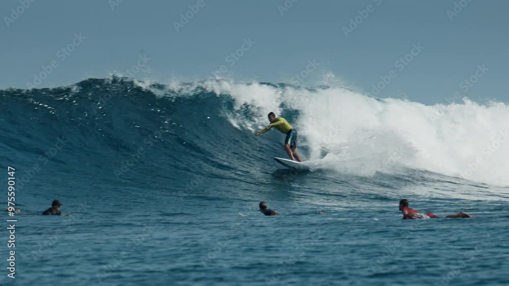 Advanced male surfer rides ocean wave in the Maldives and performs turns