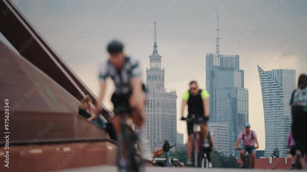 custom made wallpaper toronto digitalSlow motion cyclists ride bicycles on pedestrian bridge over river in Warsaw city. Relaxed bokeh blurred people walking along modern bridge. Focus on high-rise downtown buildings skyscrapers skyline
