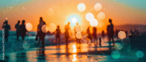 People enjoying a peaceful beach scene as the sun sets with bokeh light effects adding a dreamy quality to the serene moment.