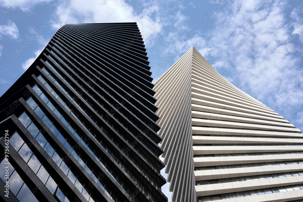 Two beautiful modern office skyscrapers against the sky. Building exterior, business, construction industry. Two beautiful modern office skyscrapers against the sky. Building exterior, business, construction industry.