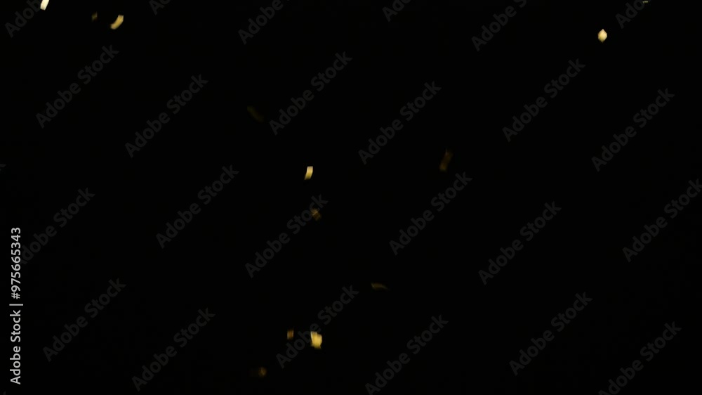 real gold confetti rain isolated on black background,  texture decoration overlay template for festive holiday celebrations