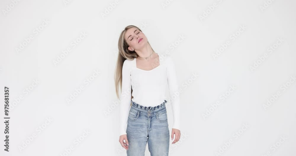Relaxed female makes rotation movements with head on white background. Young woman takes moment to relieve tension after hard work in office slow motion Relaxed female makes rotation movements with head on white background. Young woman takes moment to relieve tension after hard work in office slow motion