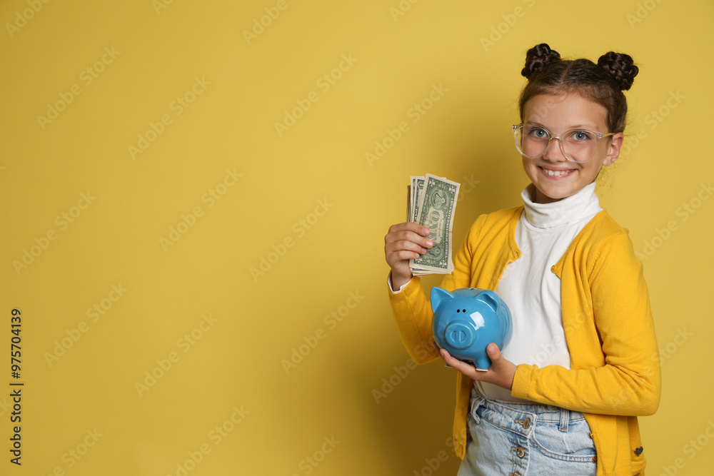 Pocket money. Cute girl with piggy bank and dollar banknotes on yellow background, space for text Pocket money. Cute girl with piggy bank and dollar banknotes on yellow background, space for text