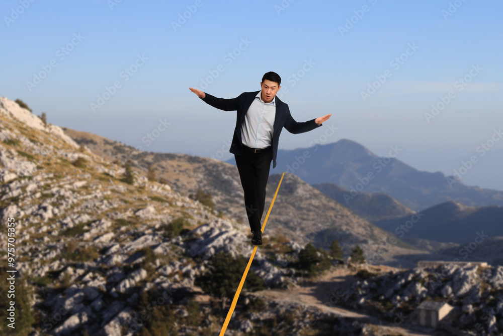 Businessman walking rope in mountains. Concept of risk and balance Businessman walking rope in mountains. Concept of risk and balance