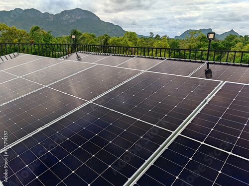 Solar Power: A Row of Solar Panels on a Rooftop Against a Cloudy Sky, with Mountains in the Distance