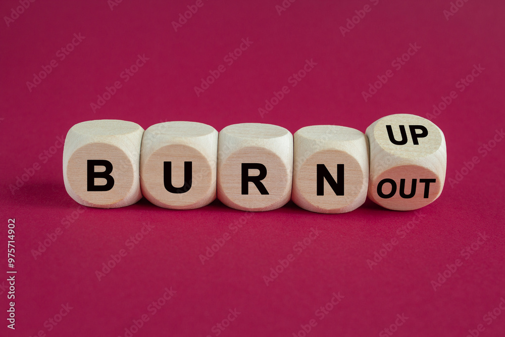 Turned a wooden cube and changes words 'burnout' to 'burn up' or vice versa. Beautiful pink background. Business, psychological and burnout concept. Turned a wooden cube and changes words 'burnout' to 'burn up' or vice versa. Beautiful pink background. Business, psychological and burnout concept.