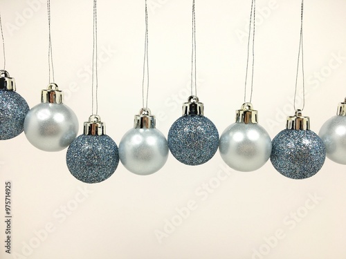 Blue round shiny Christmas tree balls hanging in a row on a white background