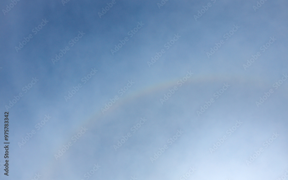 Naklejka premium Scenic sunbeams through the clouds with circular rainbow in the blue sky, Cloudscape 