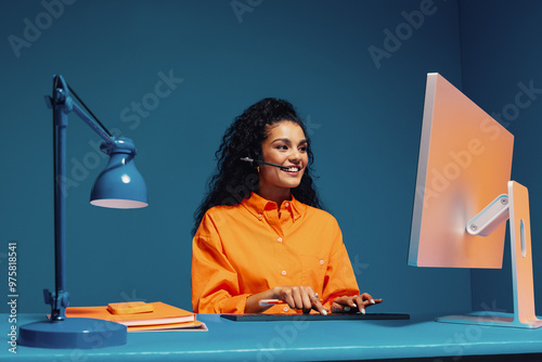 Smiling female agent wearing headset and typing on keyboard photo