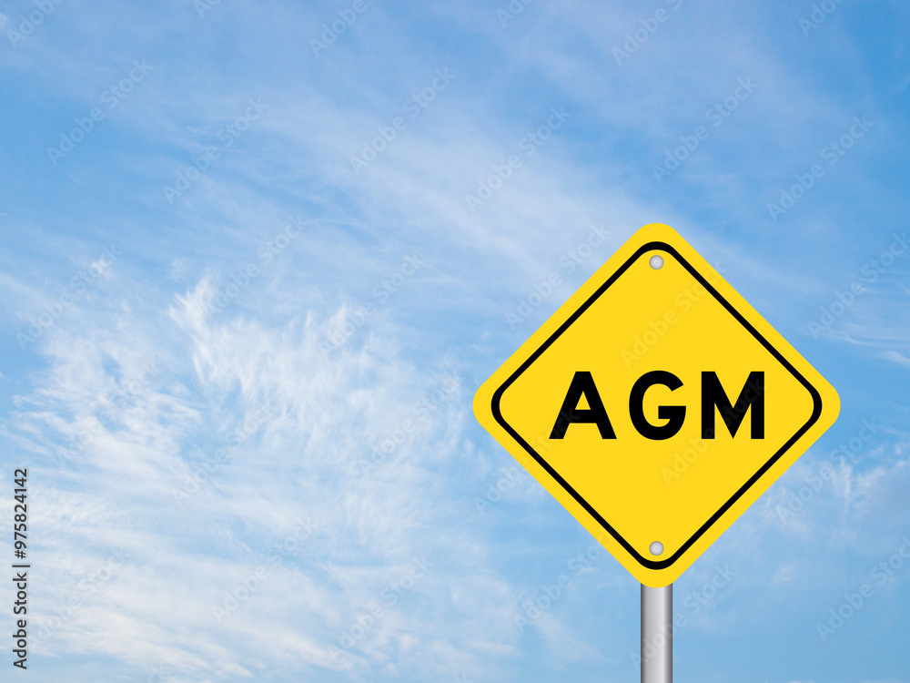 Yellow transportation sign with word AGM (Abbreviation of annual general meeting) on blue color sky background Yellow transportation sign with word AGM (Abbreviation of annual general meeting) on blue color sky background