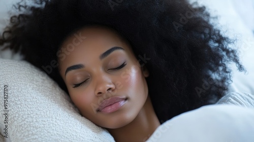A woman with dark hair is sleeping on a white pillow