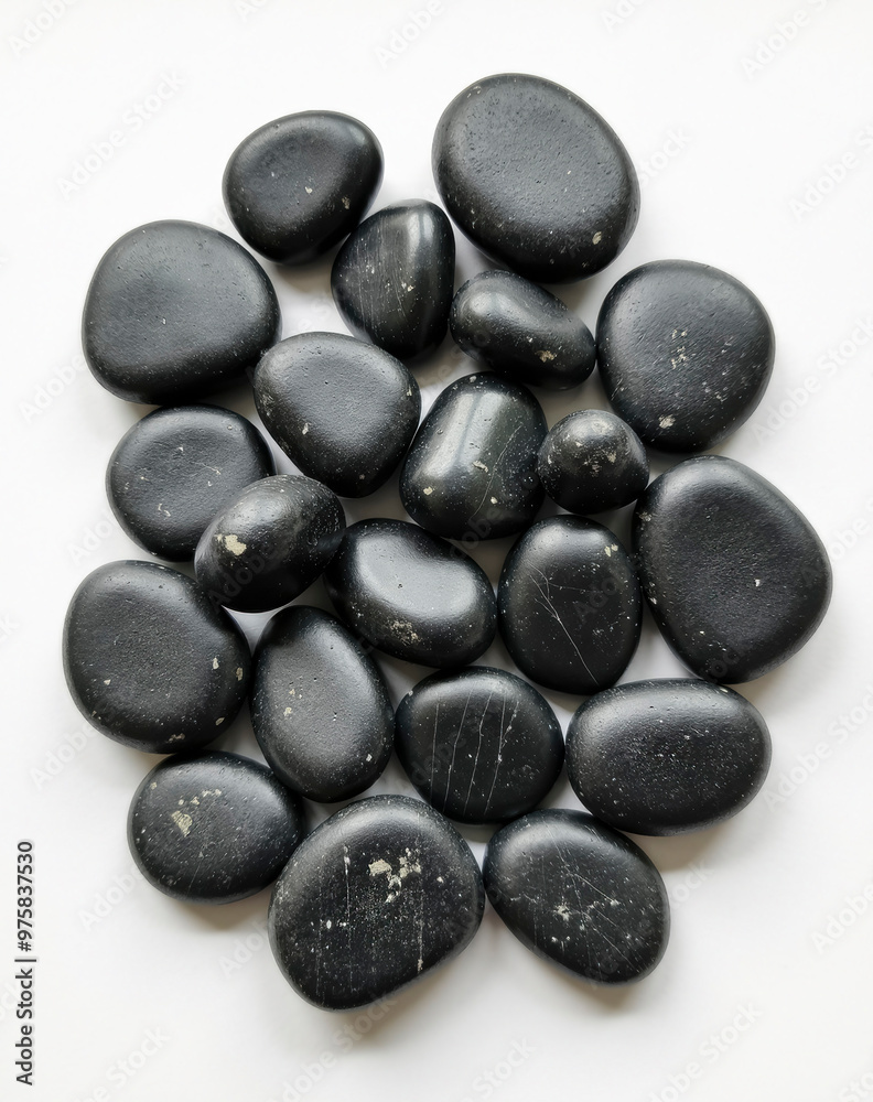 A collection of dark, round pebbles with a smooth, polished surface. A collection of dark, round pebbles with a smooth, polished surface.