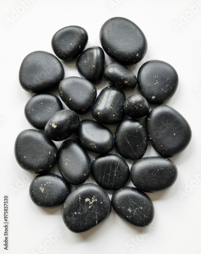 A collection of dark, round pebbles with a smooth, polished surface.