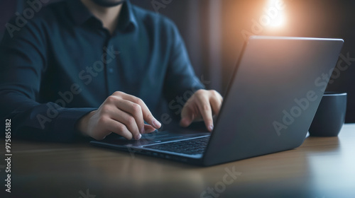 Man using digital tablet and working on laptop computer on office table