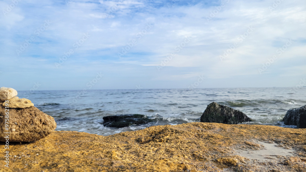 Seascape background with rocks in summer daytime. View of the Black Sea behind a large brown rock Seascape background with rocks in summer daytime. View of the Black Sea behind a large brown rock