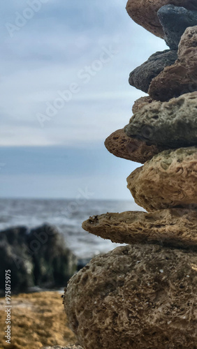 A stone structure close up on the Black Sea coast. The sea with black stones in the background is blurred