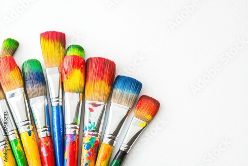 A group of paint brushes with rainbow-colored paint on the bristles, vibrant and creative, isolated on white background