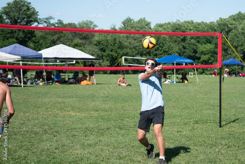 Volleyball player bump setting the ball during a grass doubles tournament