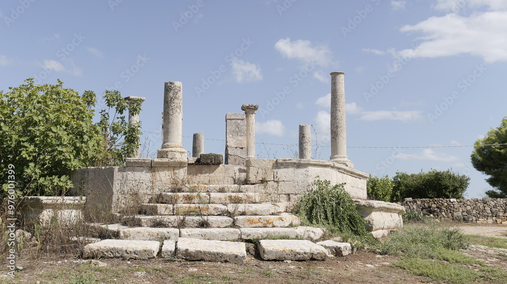 Ancient stone ruins with pillars and steps under a clear blue sky, surrounded by nature Ancient stone ruins with pillars and steps under a clear blue sky, surrounded by nature