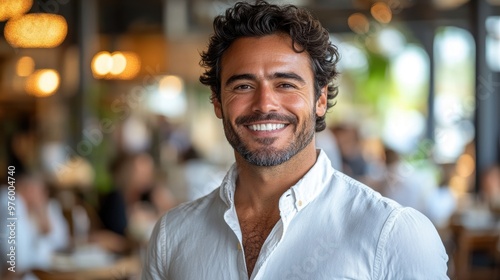 Smiling handsome young Latin business man entrepreneur using tablet standing in office at work. Happy male professional executive ceo manager holding tab computer looking at camera, portrait.