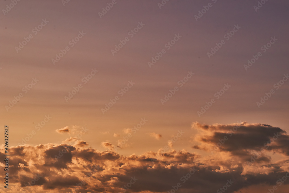 Naklejka premium Serene Sunset Sky with Soft Clouds