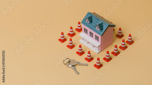 Obraz na płótnie A house is surrounded by orange and white cones. A key is laying on the ground in front of the house, Concept of caution and warning, as if the debt is being protected from potential harm w salonie