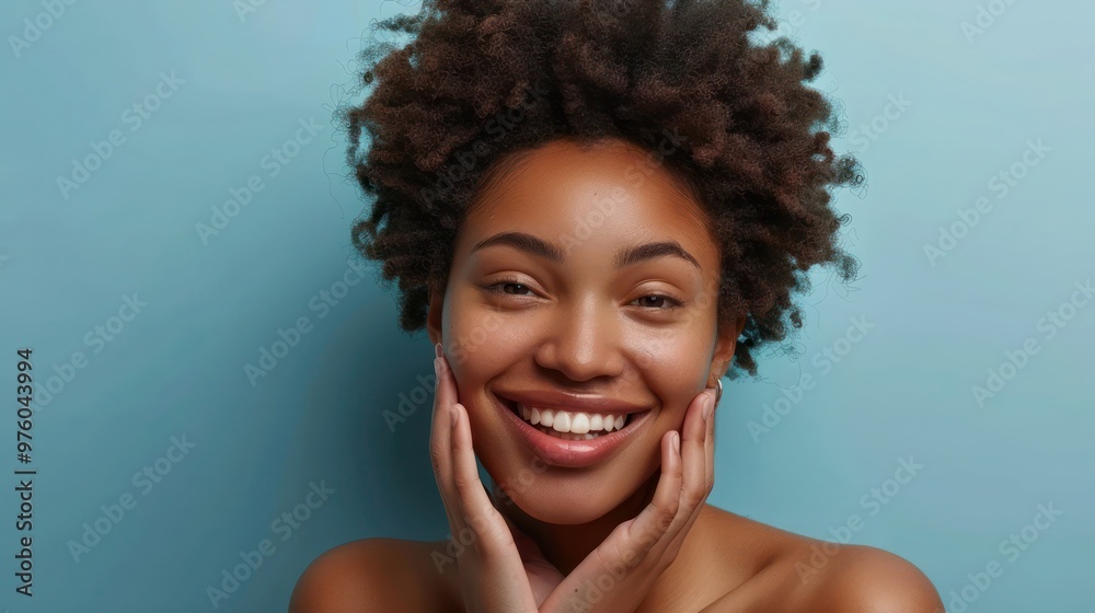 Beautiful happy African American young woman with afro hair and perfect smooth skin complexion applying putting creme on face doing daily routine. Skincare, cosmetology and spa concept Beautiful happy African American young woman with afro hair and perfect smooth skin complexion applying putting creme on face doing daily routine. Skincare, cosmetology and spa concept