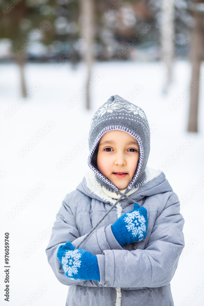 Obraz premium Beautiful little girl standing in a park or forest. Happy childhood. Holiday winter concept. Children activity.