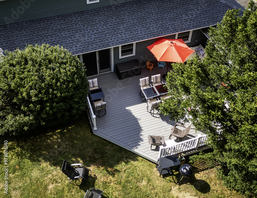 Looking down at a backyard composite deck with furniture set up for a party